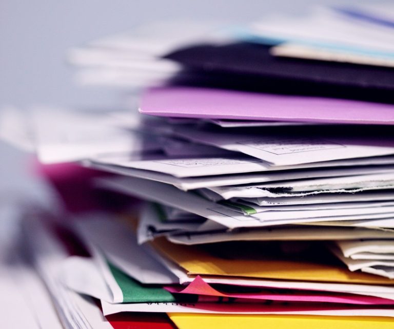 Ein Stapel bunter Papierblätter in verschiedenen Farben und Texturen.